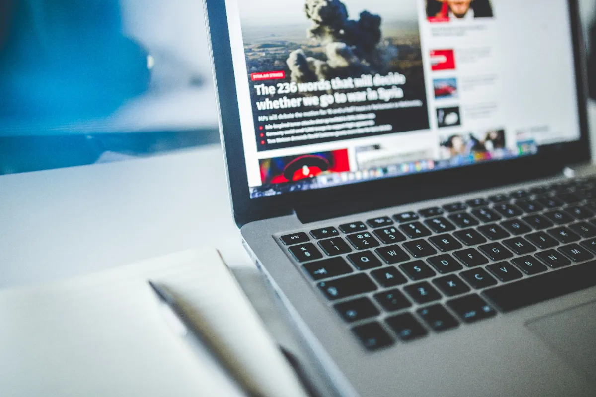 A laptop screen showing a news homepage densely packed with headline tiles, thumbnails and promotional panels
